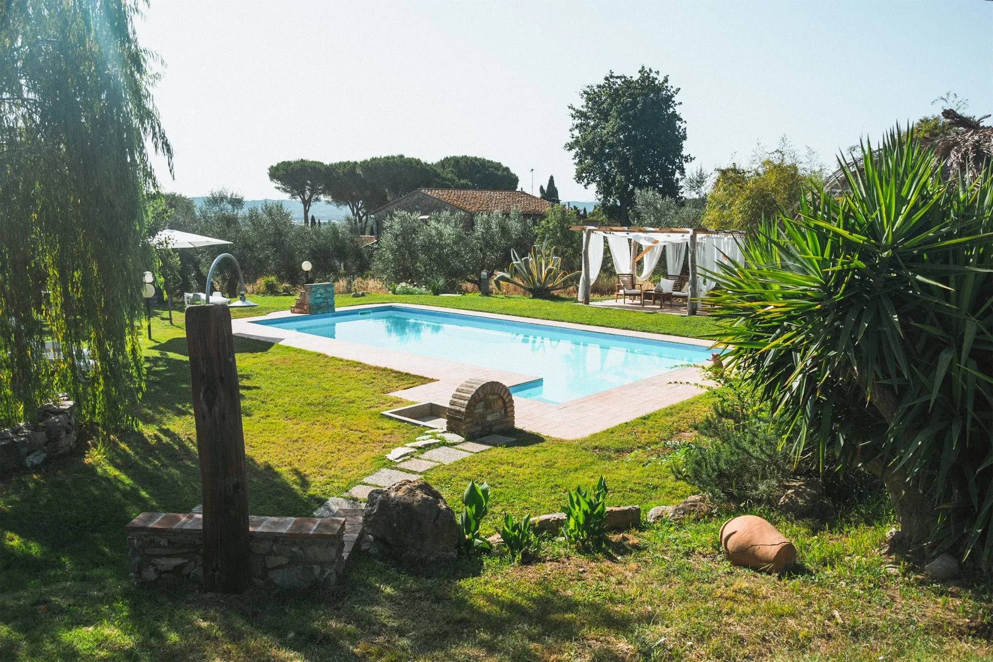 Giardino della tenuta con la piscina, il gazebo bianco e le piante grasse in primo piano: foto dallo shooting fotografico per Colle Vento