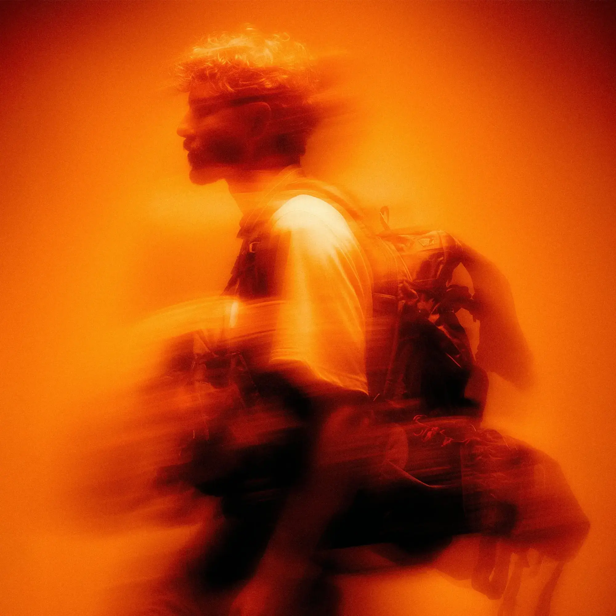 Francesco Sacchini di profilo, mosso, su fondo arancio.