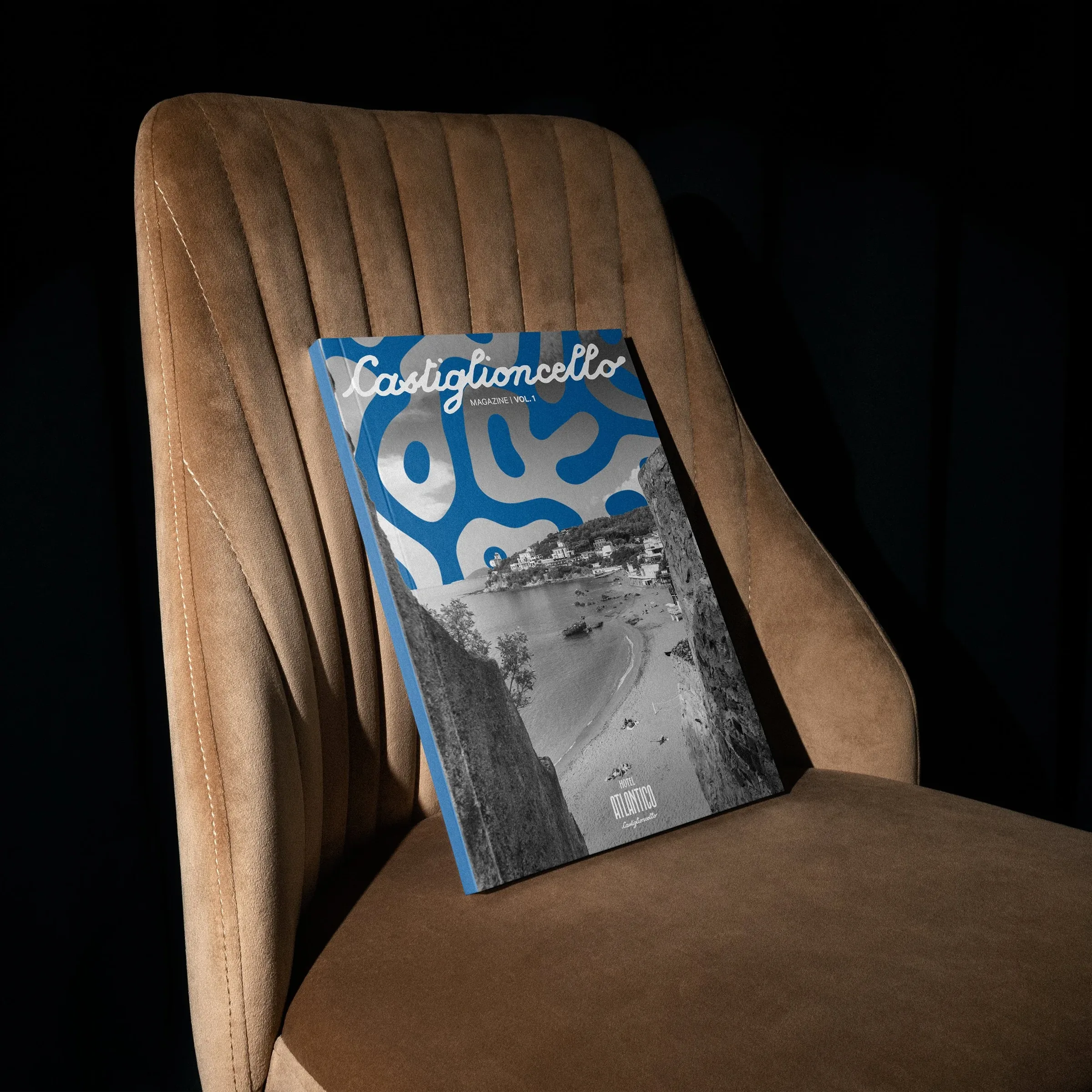 Concept di copertina del magazine Castiglioncello con forme organiche blu e una foto in bianco e nero, su una poltrona in velluto: mockup editoriale