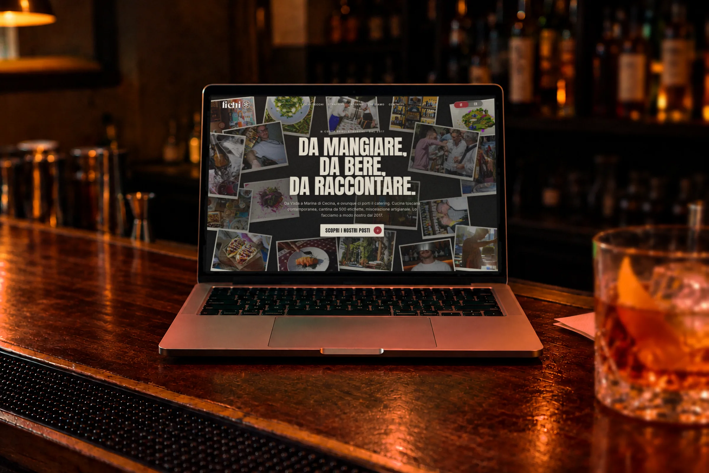 Un portatile al centro del bancone di un cocktail bar, con aperta la home del sito di i Fichi, e un drink ambrato di lato. Copertina del progetto sito e activation