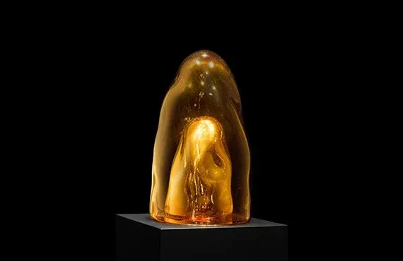 Forma ambrata e traslucida su un piedistallo nero, l'opera di Tristano di Robilant esposta a ORObyRUFFINO alla Milano Design Week 2024