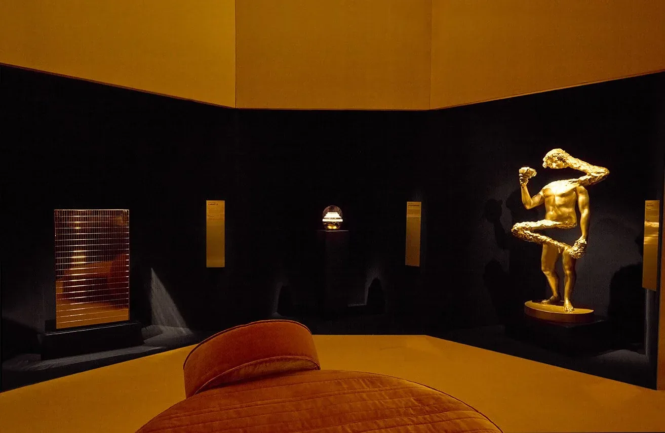 La sala espositiva di ORObyRUFFINO con le opere illuminate e la scultura dorata di Ettore Marinelli a destra: allestimento della mostra 2024
