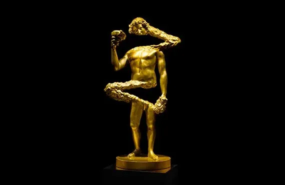 Scultura dorata di una figura umana su fondo nero, l'opera di Ettore Marinelli esposta a ORObyRUFFINO alla Milano Design Week 2024