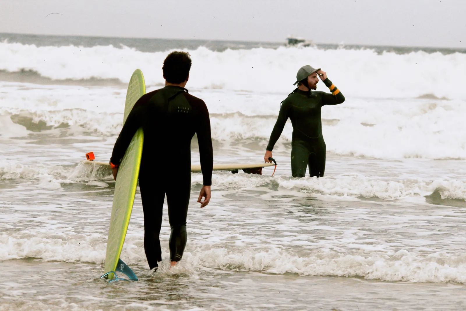 Francesco di spalle entra in acqua con la tavola da surf a Biarritz
